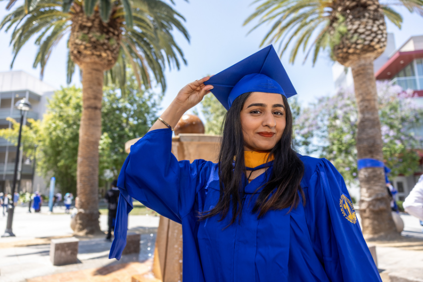 Graduate posing with cap and gown