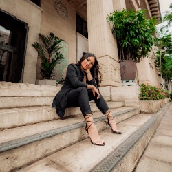 Samantha Magbulos Photo of justice studies graduate student Samantha Magbulos sitting on the steps of a courthouse